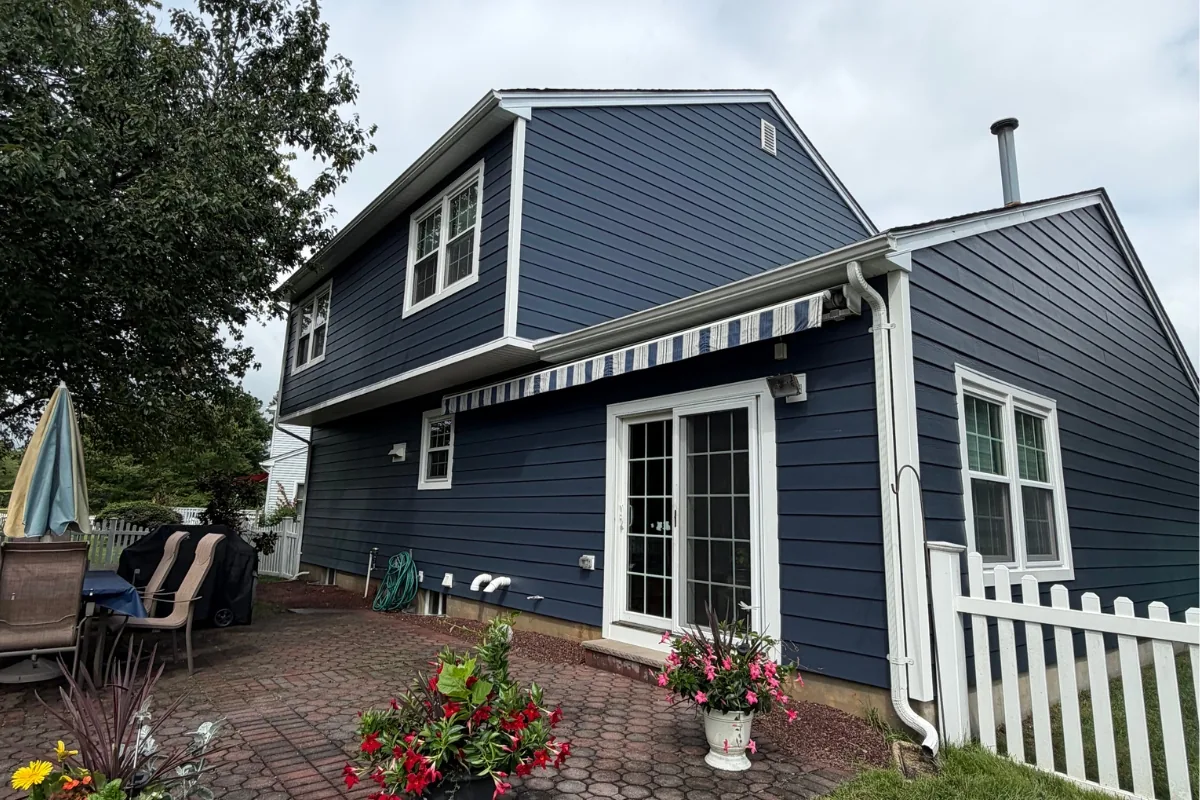 Navy James Hardie lap siding and white seamless gutters on the rear elevation of a South Brunswick, NJ home